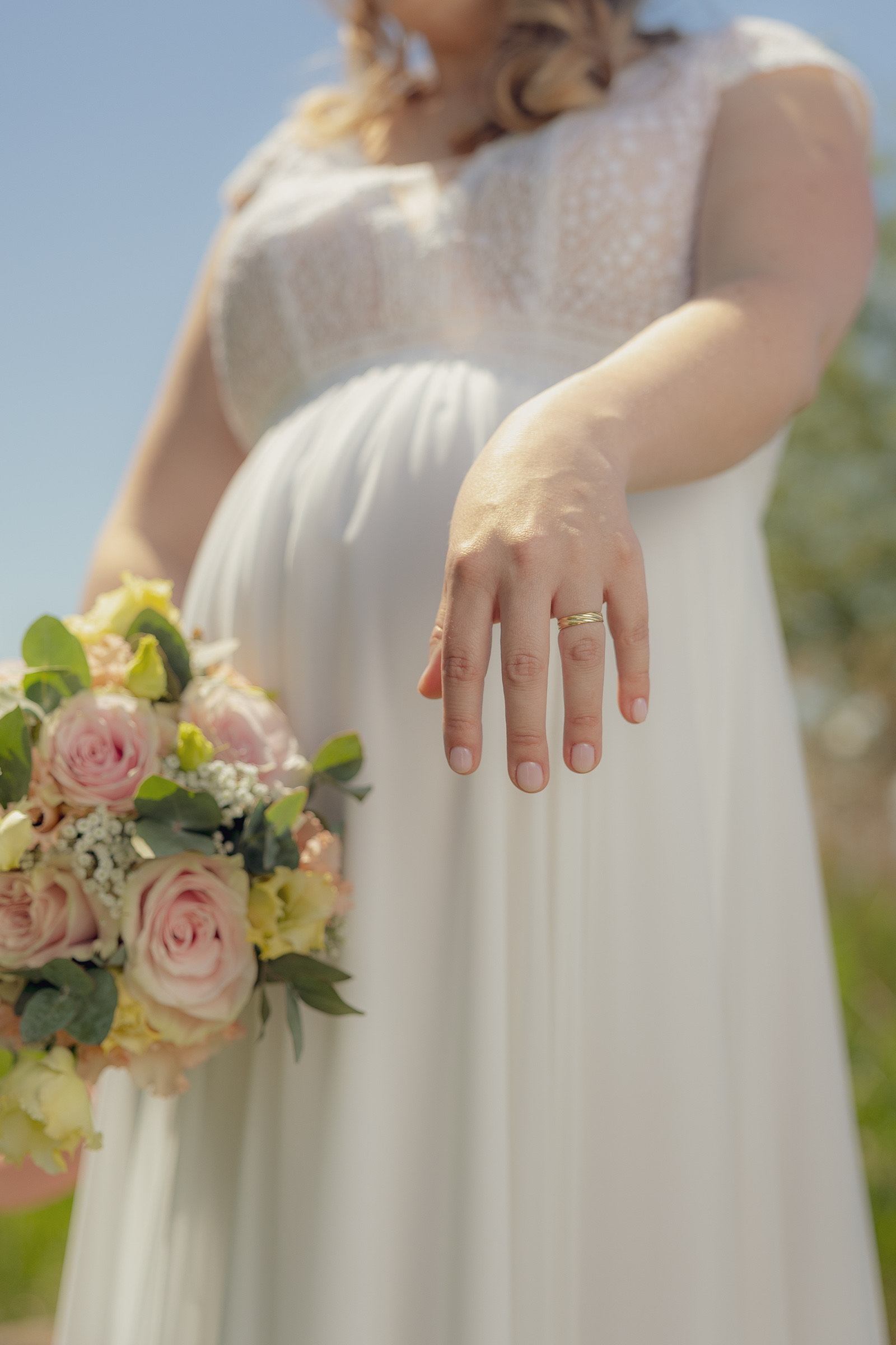 Angelas Hand mit dem Ehering, daneben der Brautstrauss